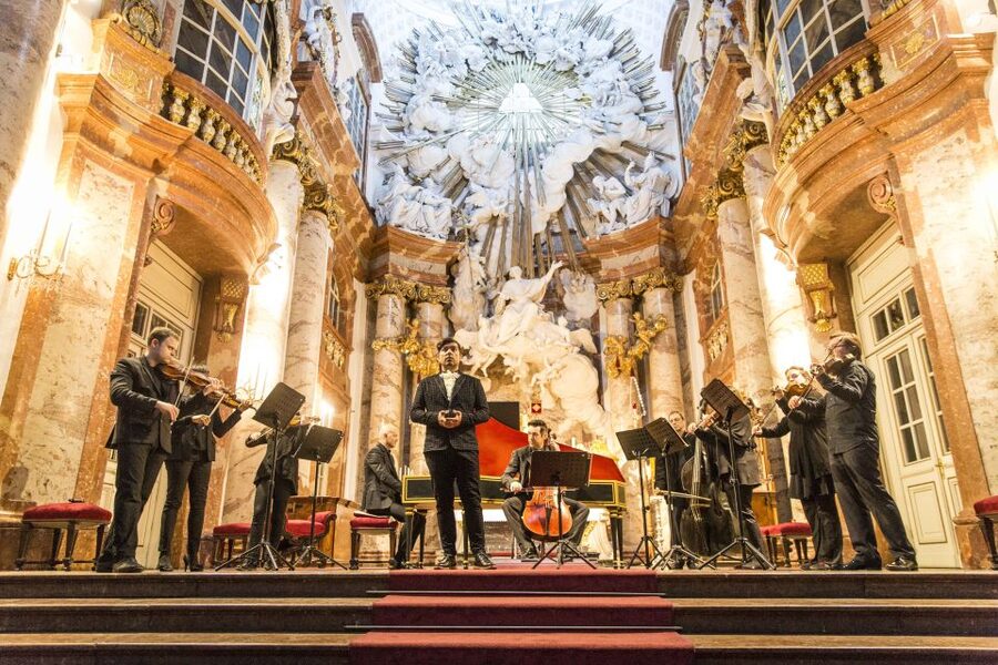 An orchestra playing under the gilded dome of the Karlskirche in Vienna
